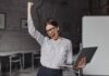 Laptop Diwali Offer 2021: Up To 60% Off, so Hurry Up! Business woman with laptop in hand is happy with success. portrait of woman in glasses and striped blouse enthusiastically screaming and making winning gesture. Free Photo