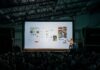 5 Ways to Increase Sales for Your Event person discussing while standing in front of a large screen in front of people inside dim-lighted room