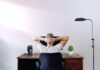 What Are the Main Advantages and Disadvantages of Working from Home? man holding his head while sitting on chair near computer desk