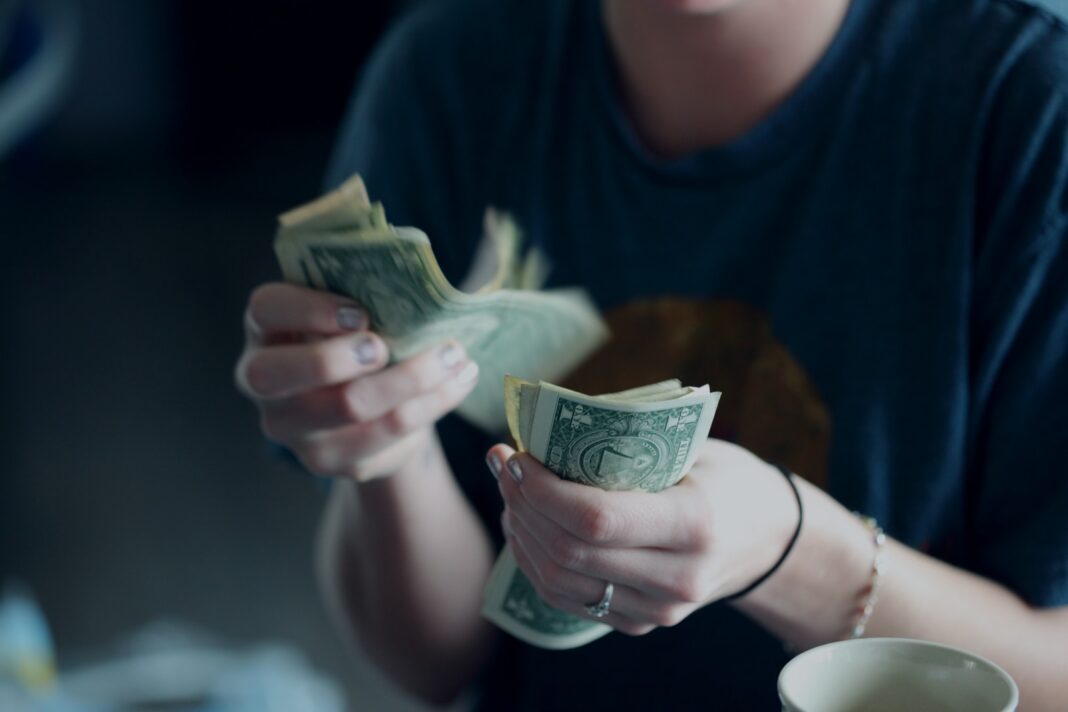 Photo by Sharon McCutcheon focus photography of person counting dollar banknotes