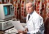 Improving Healthcare with Data Analytics man reading papers in front of computer