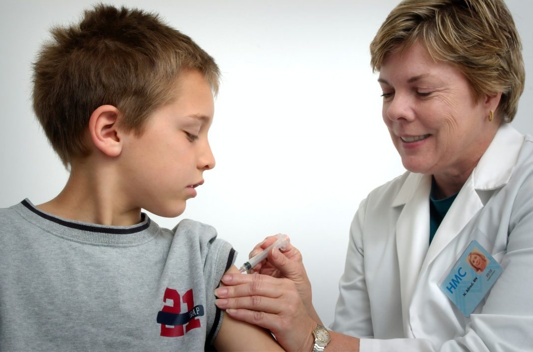 Photo by CDC woman inject boy on arm