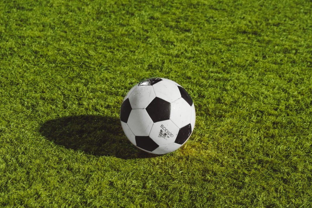 Photo by Wesley Tingey white and black soccer ball on grass field