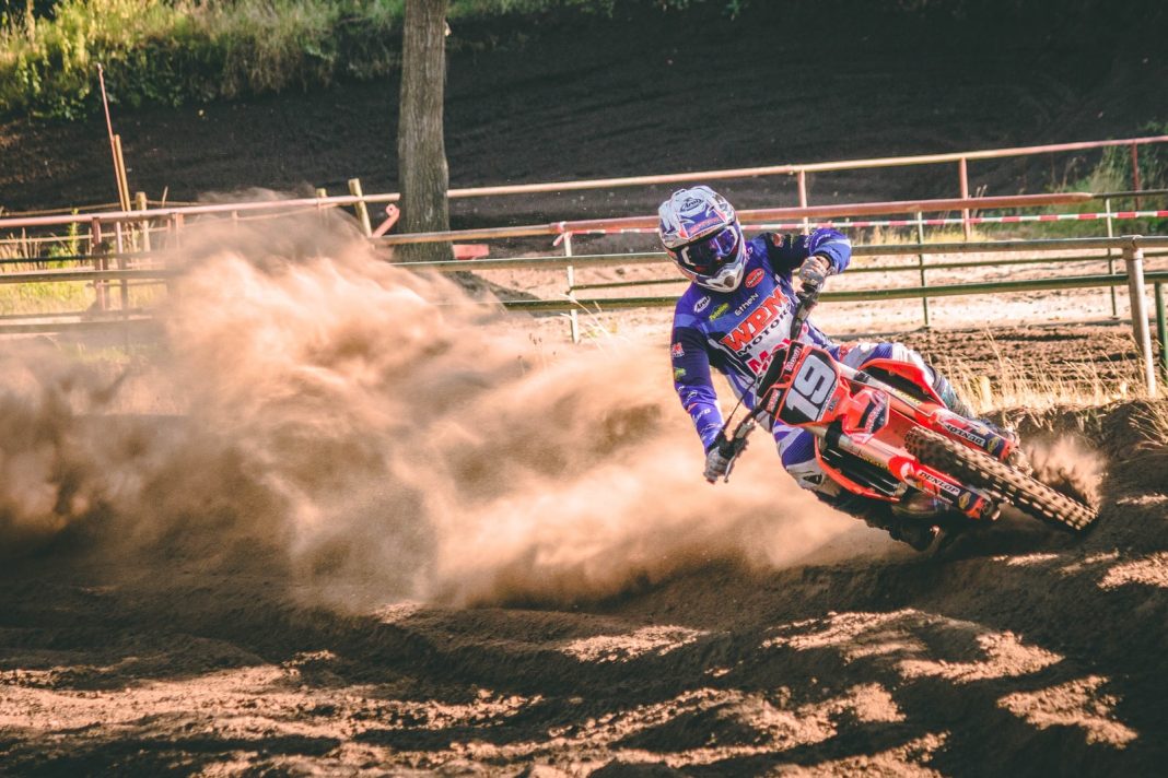 Photo by Appic person riding on motocross dirt bike drifts on race track