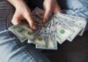 Will a personal loan raise my credit score? fan of 100 U.S. dollar banknotes
