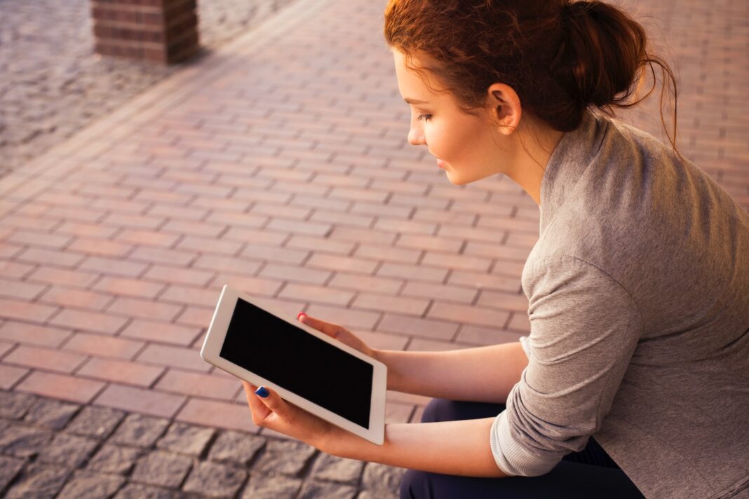 Photo by Anna Demianenko woman holding white iPad
