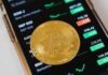 Why Investing in Bitcoin Is Smart? Gold Round Coin on Top of a Cellphone