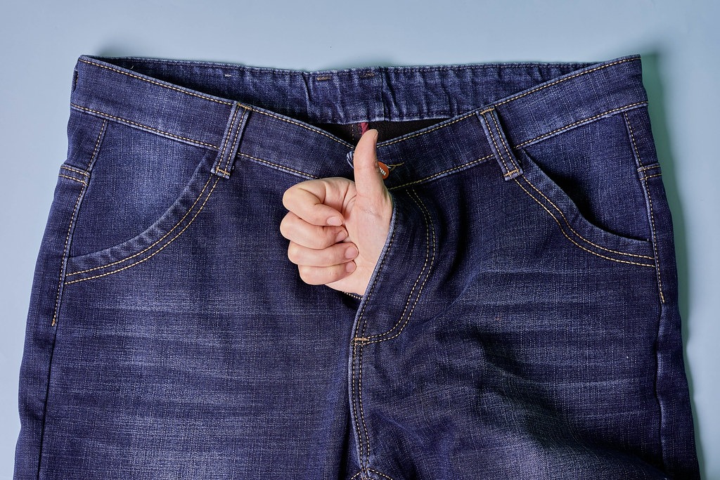 Hand thumb raised from jeans. Treatment of erectile dysfunction and sexual disorders