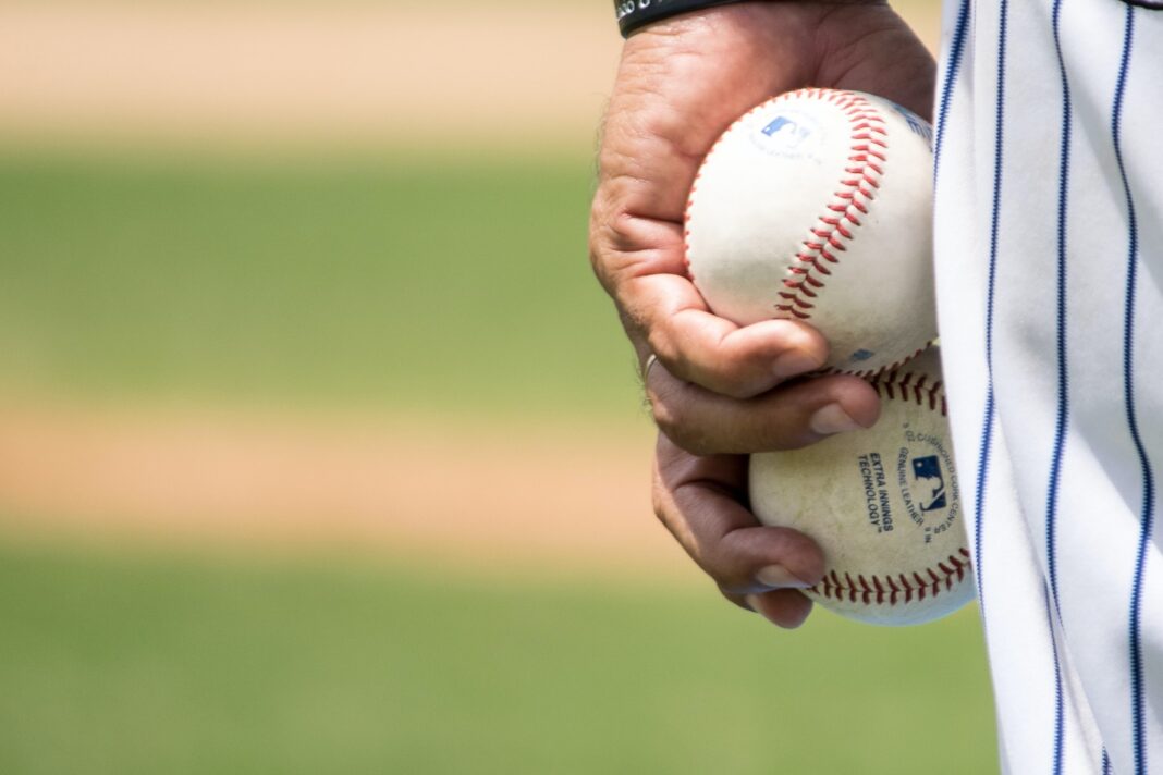 A close-up of a person holding a baseball Description automatically generated with medium confidence