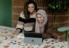 Unlocking Your Business’s Potential: Coaching Strategies for Optimal Workload and Productivity Two women sitting at a table with a laptop