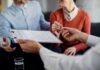 5 Strategies for Negotiating Rent with Your Landlord closeup-unrecognizable-couple-signing-contract-with-financial-advisor (1).jpg