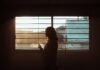 How Nursing Home Abuse Victimizes Chicago’s Elderly woman in white and black stripe shirt standing near window