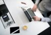 Importance of UI design in modern business person using laptop on white wooden table