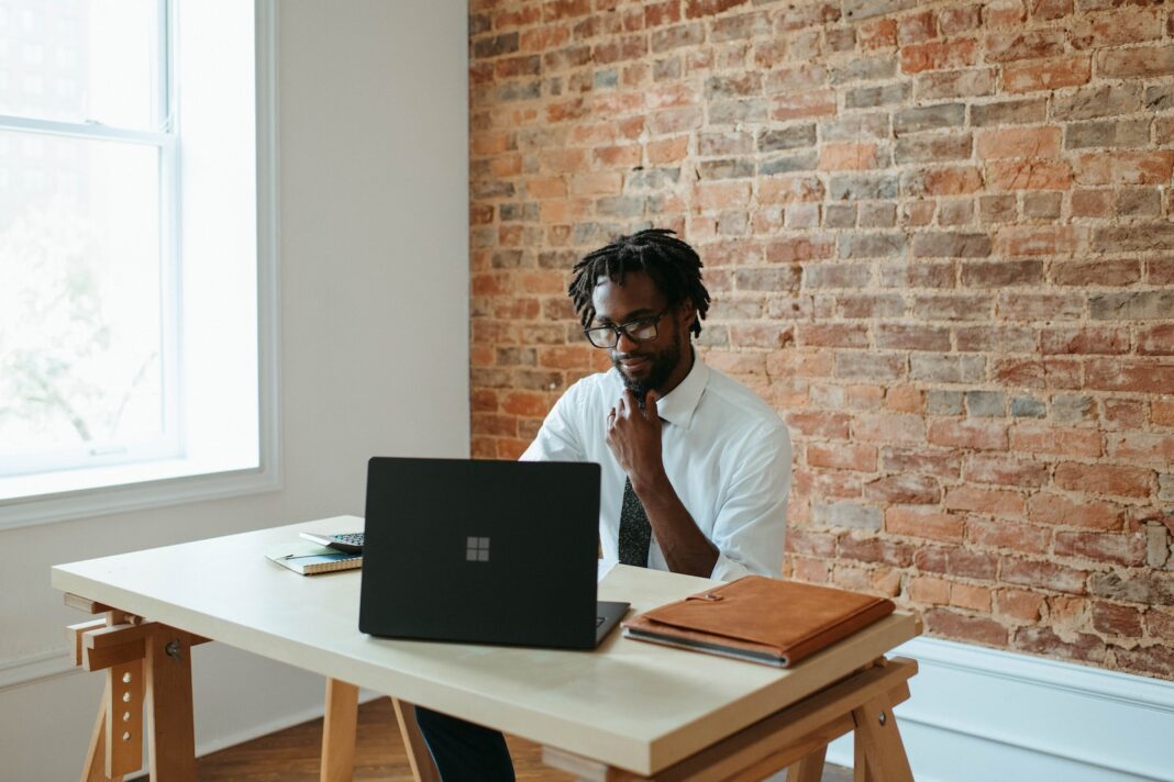 Photo by Microsoft 365 a man sitting at a table in front of a laptop