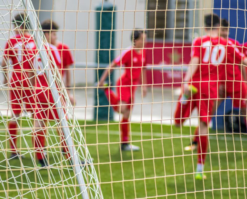 Photo by Ravi Avaala soccer players in red jersey shirt playing soccer during daytime