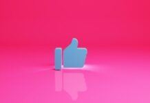 How to Use Facebook Reactions and Likes in Your Marketing Efforts? a thumbs up sign on a pink background