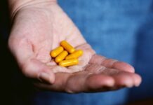 Unmasking the World of Health Supplements: A Comprehensive Guide yellow medication pill on persons hand