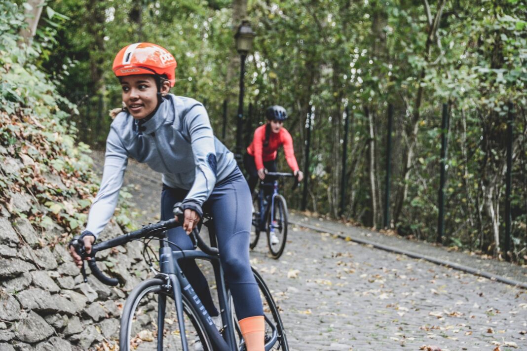 Photo by Coen van de Broek woman biking during daytime