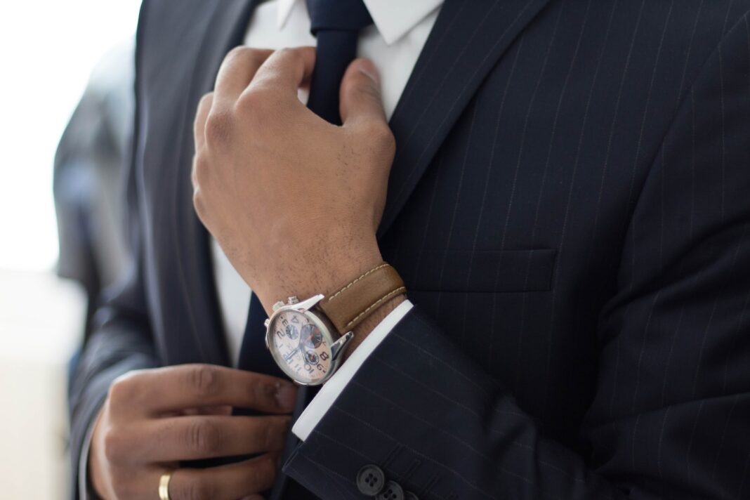Photo by Ruthson Zimmerman man wearing watch with black suit