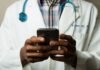 Exploring Parental Health Insurance Plans: A Comparative Analysis person wearing lavatory gown with green stethoscope on neck using phone while standing