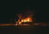 Recognized Excellence: San Antonio’s Award-Winning Burn Injury Lawyers burning grey sedan near trees and signboard at night