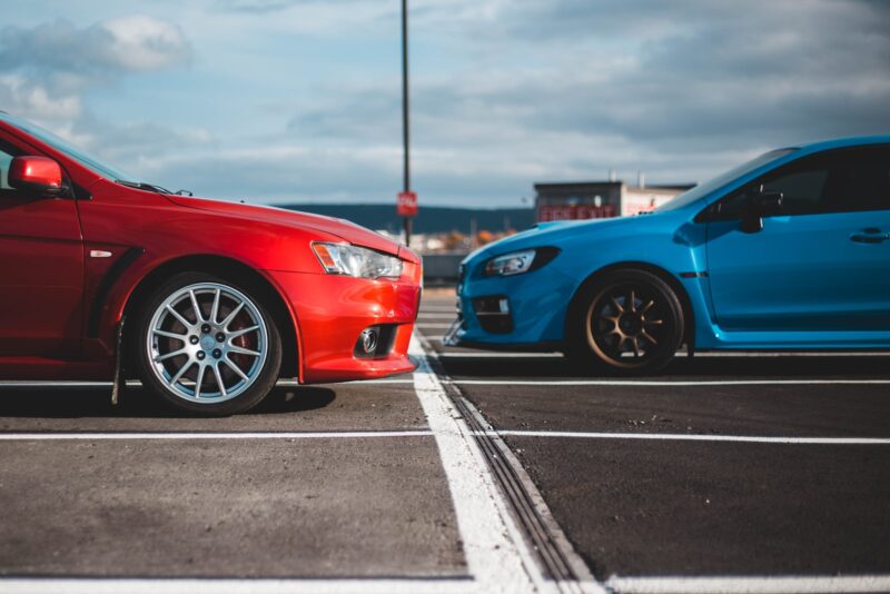Photo by Erik Mclean blue and red cars in parking lots