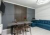 Upward Warmth: Embracing Modern Living with Vertical Radiators Modern room interior with table and armchairs between TV and couch at home with shiny lamp