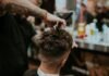 The Evolution of Haircut Designs: From Classic to Modern man in black shirt holding black hair brush
