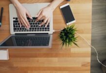 How to Leverage Humbot for Checking AI Text & Bypassing AI Detection a person typing on a laptop on a wooden table