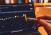 E-Trading in Black Gold: The Future of Oil Markets a person using a laptop computer with a chart on the screen