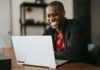 man in black blazer sitting by the table with laptop