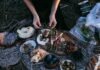 4 Reasons to Get an Outdoor Kitchen From above crop anonymous female serving yummy food including asparagus with bacon potatoes and grapes on wooden board placed on plaid during picnic in nature