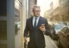 Risks Associated with Using Aave in Transactions Selective Focus Photo of Walking Man in Black Suit Carrying a To Go Cup and Briefcase While Using His Phone