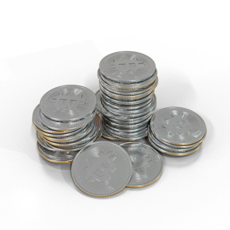 Photo by Eyestetix Studio a pile of silver bitcoins sitting on top of each other