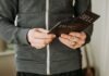 Finzilo.com Review | 👍 Pros & Cons 👎 of Trading Platform (2024) a person holding a cell phone in their hands