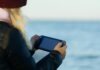 JetX Games: The Most Exciting Crash Game in India a woman holding a game controller in front of a body of water