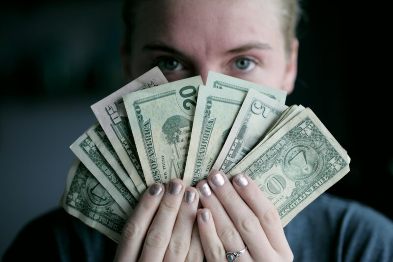 Photo by Alexander Grey person holding fan of U.S. dollars banknote