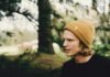 Head-Turning Promo: Beanie Hats That Keep Your Brand in Style shadow depth of field photography of man in black shirt standing near trees