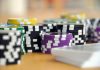 Should You Pick Online Casinos Based on Your Income Bracket? A close-up shot of stacked poker chips and playing cards on a table, perfect for casino and gambling themes.