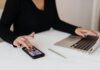 Data-Driven Success: Using Advanced Analytics to Master SEO Strategies A professional woman multitasking with a smartphone and laptop at an office desk.