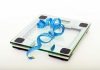 Finding the Right Weight Loss Surgeon in Torrance: Key Factors to Consider A digital glass weighing scale with a blue measuring tape, symbolizing weight management.