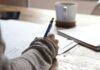 Excellence in Financial Education: Providers Delivering Superior Training person writing on brown wooden table near white ceramic mug
