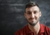 Why the Best Professional AI Headshot Generator Can Transform Your Online Image A smiling man in a red polo shirt poses for a portrait with a blurred background.