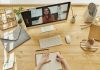 Technology in Education: Tools and Strategies for Remote Teaching Person taking notes during a video call at a neatly organized home desk, showing remote work lifestyle.
