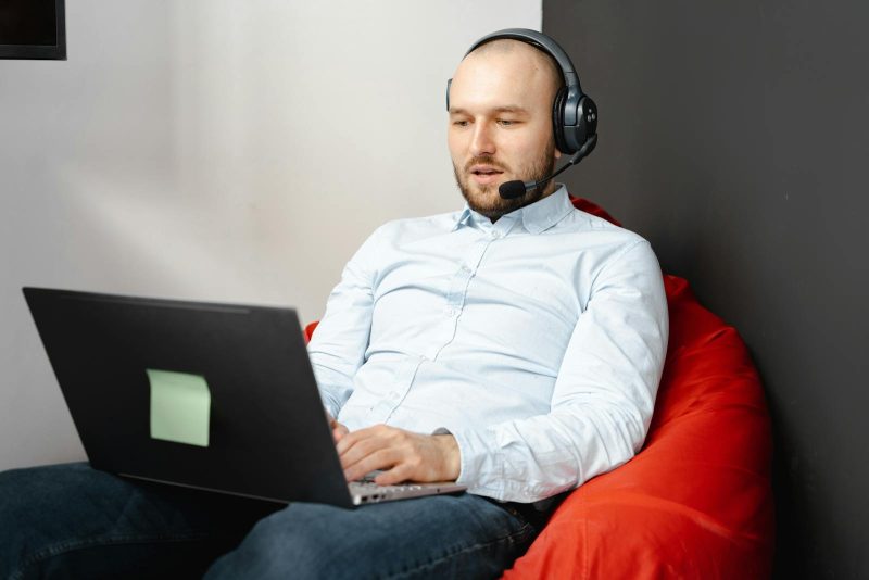 Photo by Mikhail Nilov Call center agent working remotely on a laptop with headset and microphone for customer service.