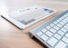How to Do Adult SEO Without Getting Penalized by Google A modern tablet displaying a search engine logo next to a wireless keyboard on a wooden desk.