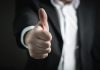 Lessons from Scaling a Business to the Top A close-up of a man's thumbs up gesture, symbolizing success and agreement.