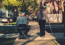 How Mobility Suppliers Are Shaping Modern Aged Care man in gray hoodie and black pants sitting on black and gray stroller during daytime