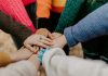 How Communities Thrive When Neighbors Show Up for Each Other person in red sweater holding babys hand