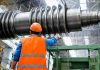 Innovation in Extrusion: The Most Efficient Twin-Screw Machines Engineer in high visibility vest and hard hat inspecting large machinery in factory setting.